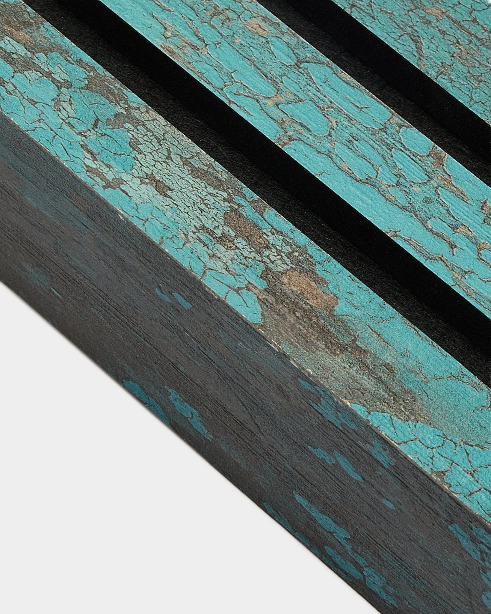 Nærbilde av WoodUpp Akupanel avslutningslamell i Oxide Blue, 6,7 cm bred, med sprukket blå maling og black spor på en rustikk Akustikkpanel-overflate.